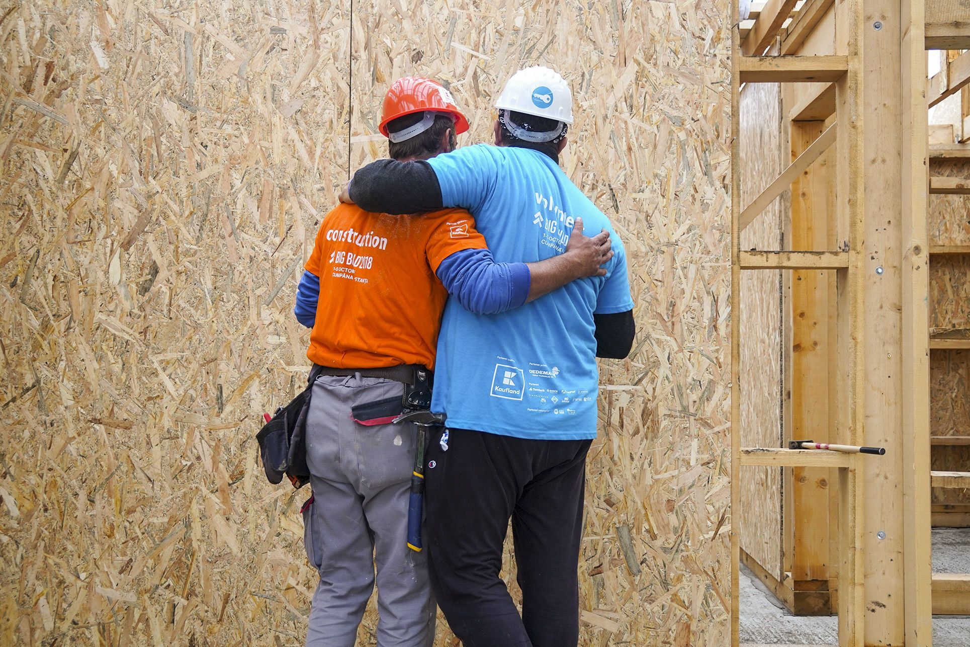 Volunteers hugging in construction site