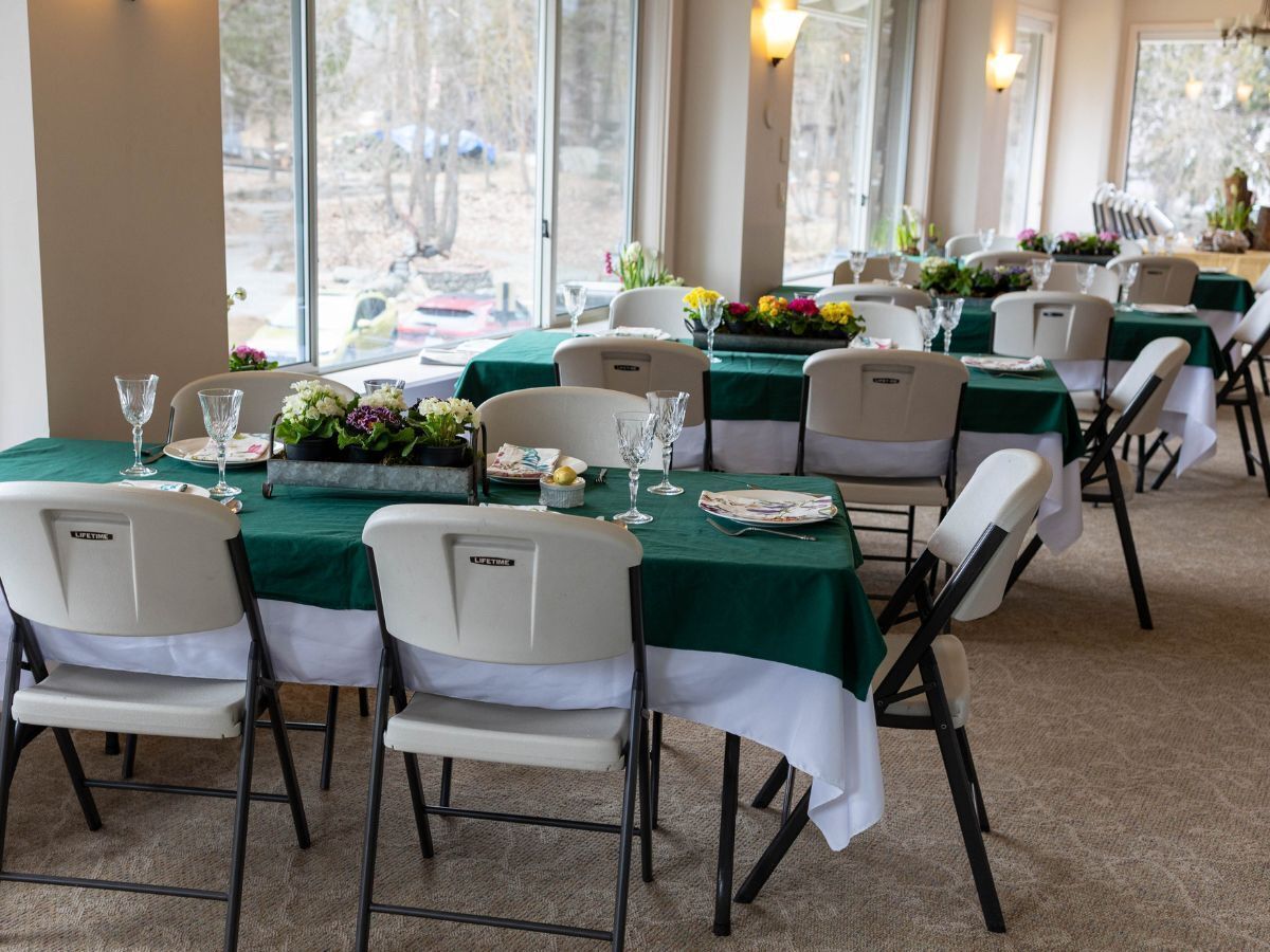 Tables and chairs decorated for dinner in Wenatchee River Institute's Sun Room.