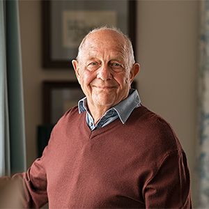 An older man smiling at home.