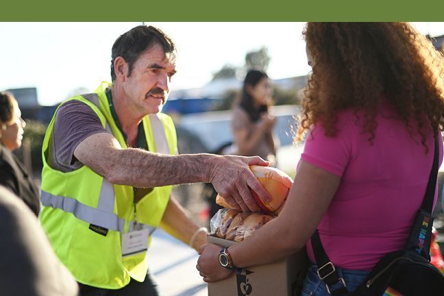 Photo of volunteer handing recipient food