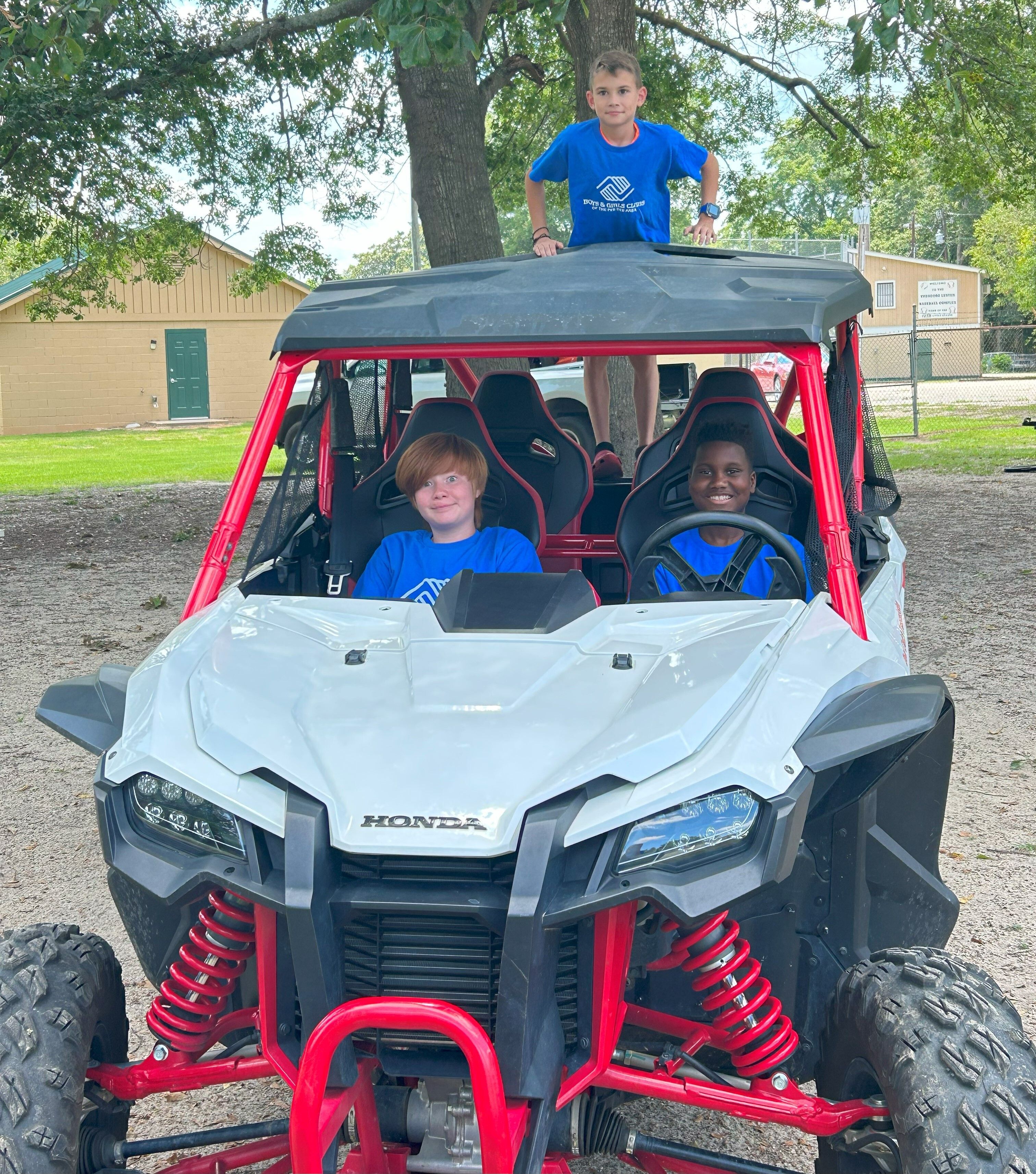 Kids from the Florence Boys & Girls Club ride in a Honda SxS