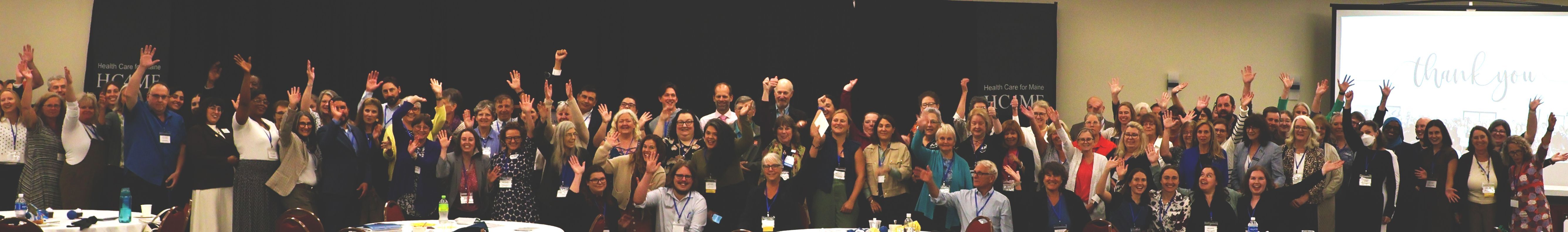 group of conference attendees waving