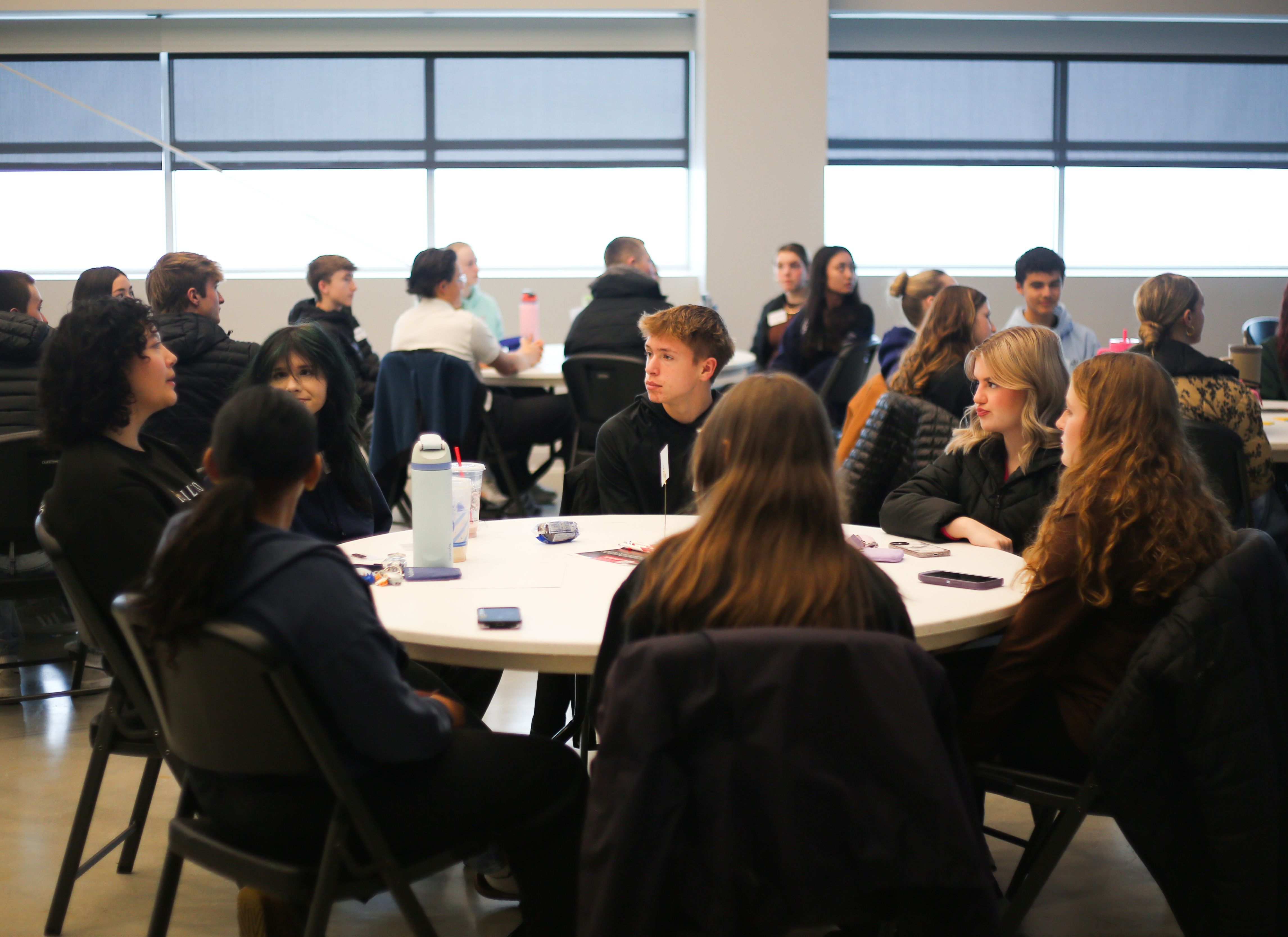 Youth Leadership Lincoln students talk at a table