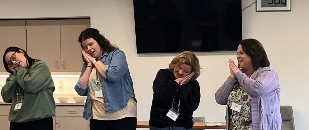 Four early childhood educators at a professional development training. They are pretending to be asleep. 