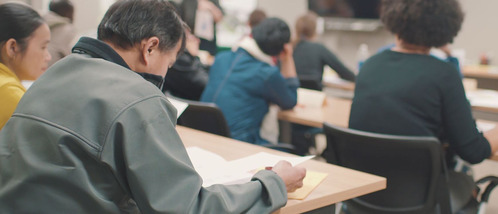 Picture of people sitting classroom style reviewing paperowrk