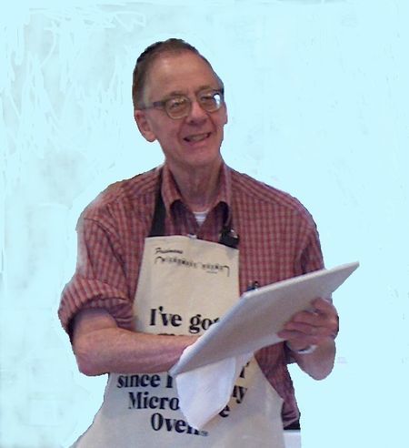 John T. Storz cooking in apron