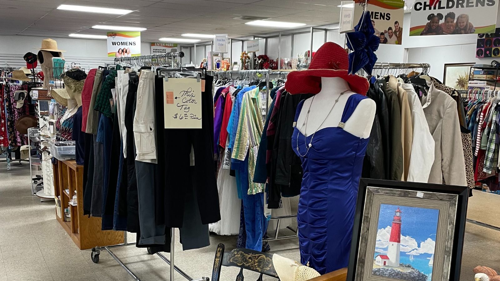 Inside NBC's thift store, showing a blue cocktail dress, red hat, and racks of clothes!