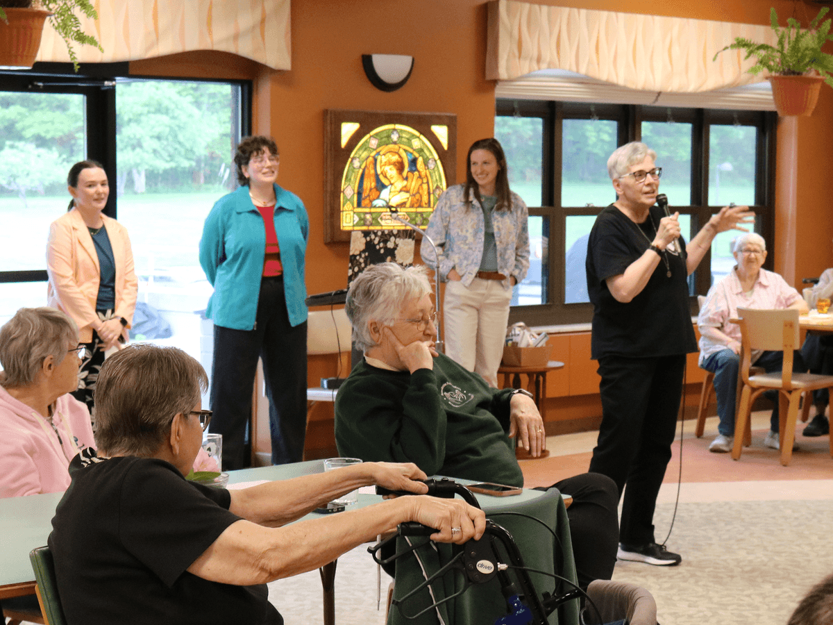 Sister Charlotte introduce the drumstick ensemble and their two numbers--Love Will Keep Us Together and Locomotion.