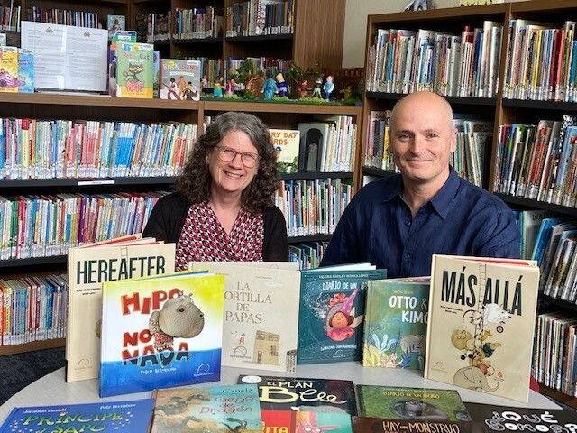 Syncretic Press publisher Enrique Moras and Atglen Public Library Director Robbyn Kehoe display Spanish-language picture books received through ARPA funds.