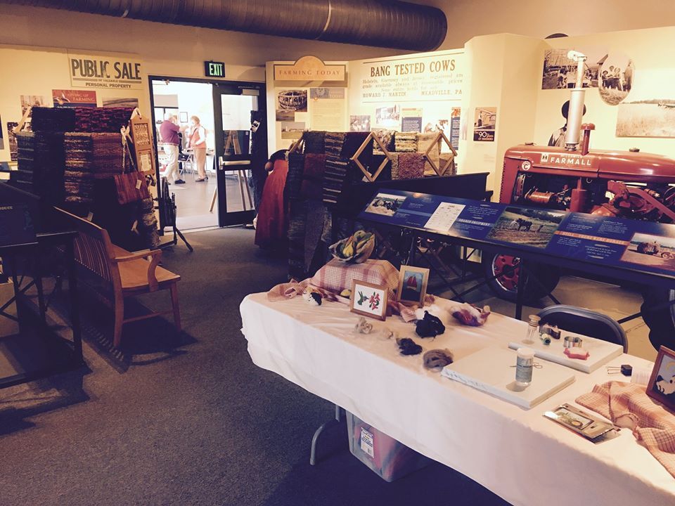 Interior of the exhibit at the Somerset Historical Center with vendor tables set up selling fiber arts.