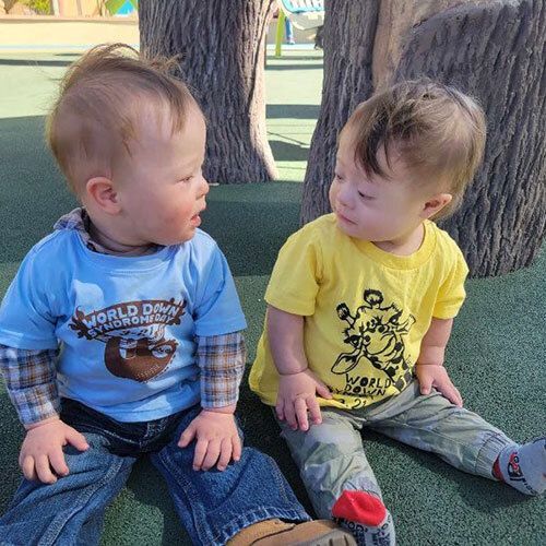 Two babies looking at each other.