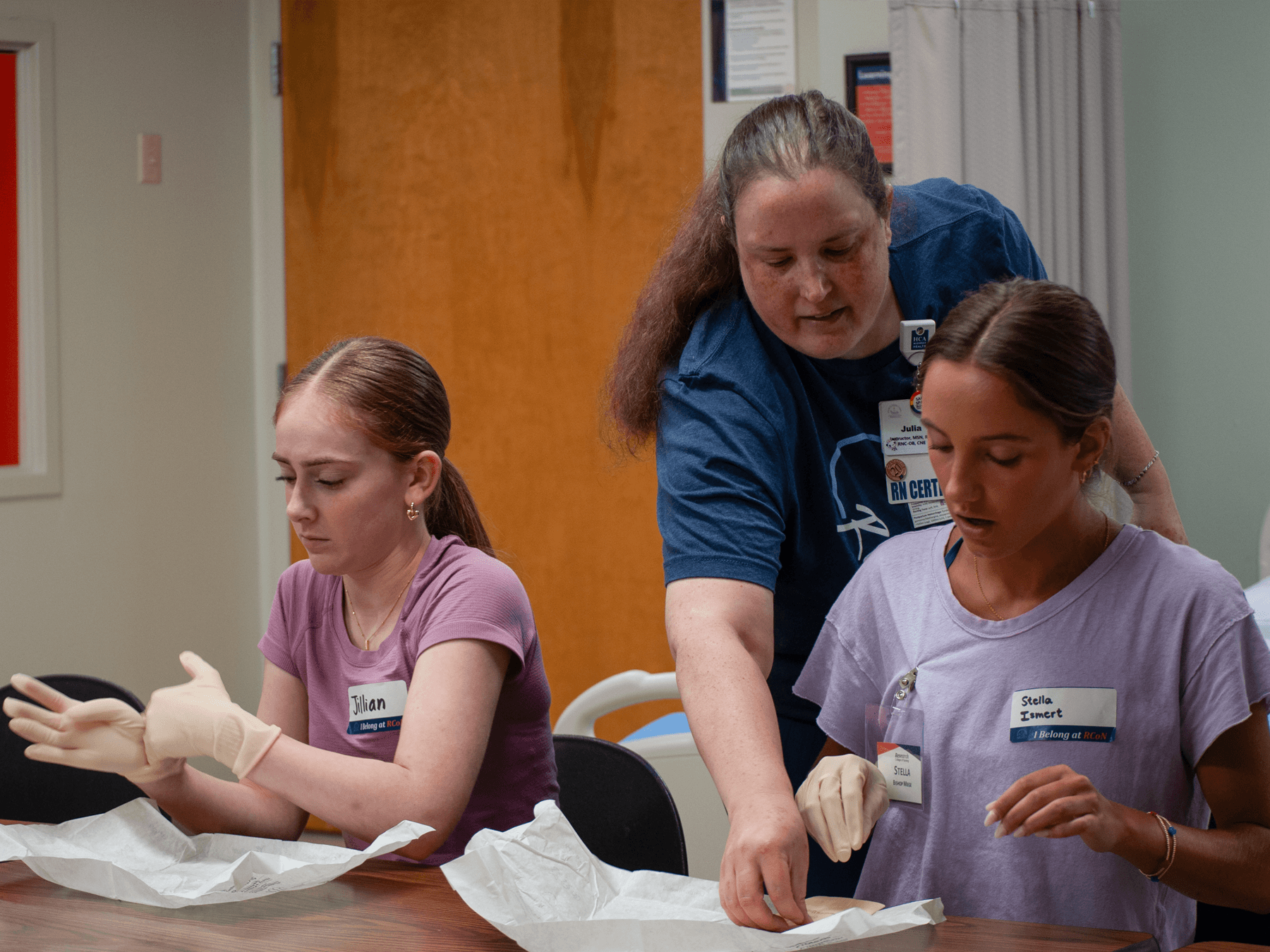 nurse educator instructing on sterile gloves
