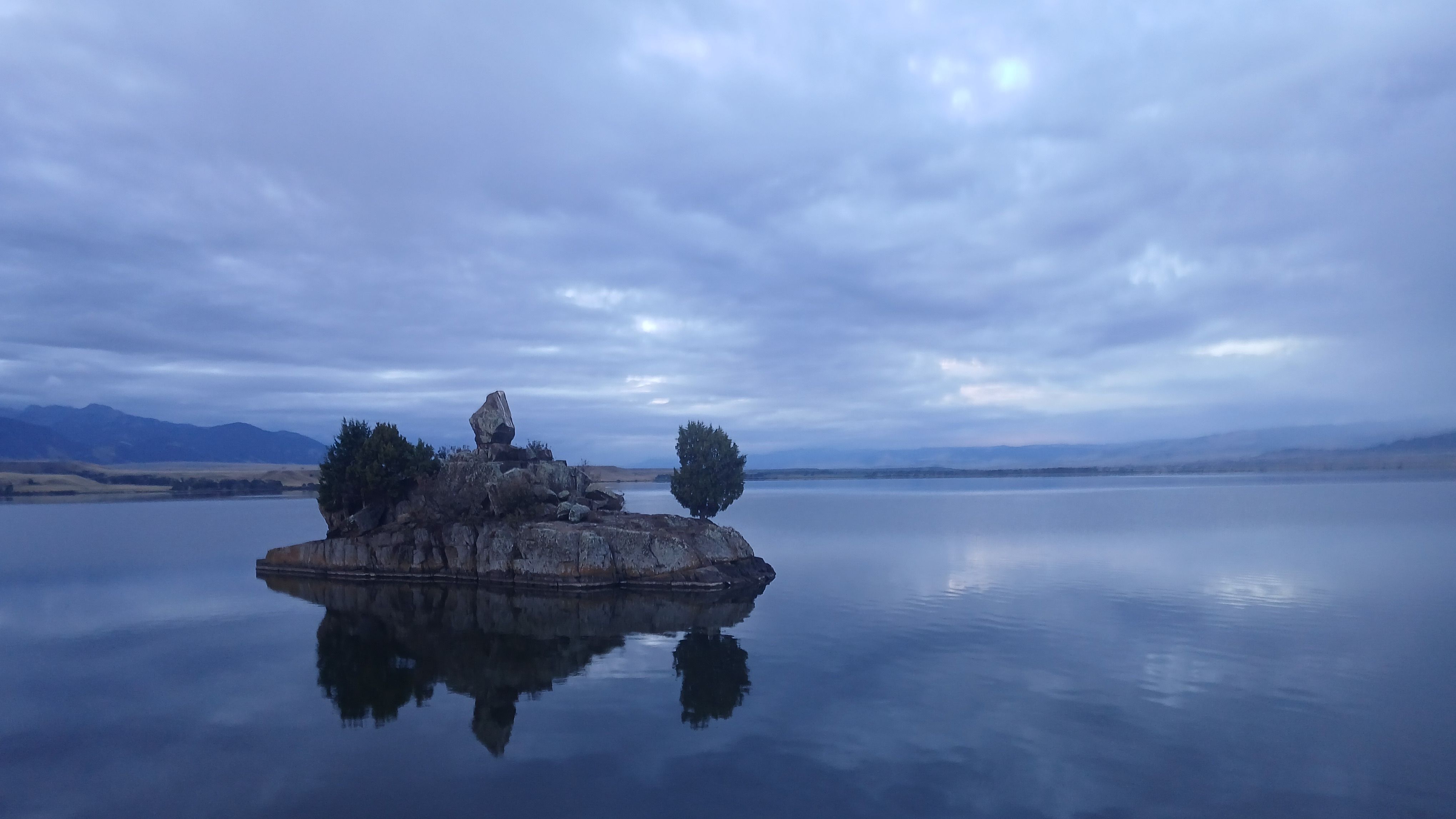 A view of an island in a lake at twilight