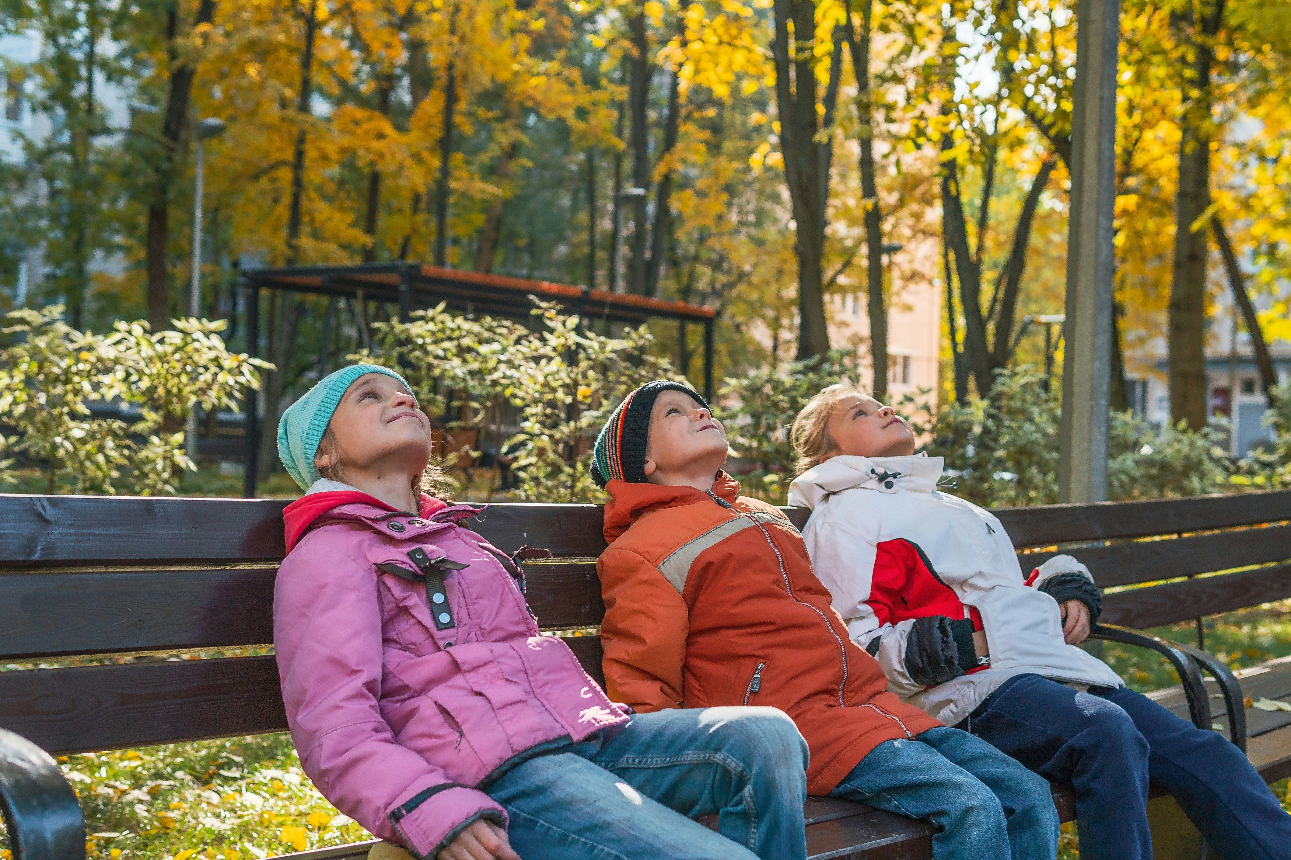 five smiling children of diverse races and genders lying in the grass under the Georgia Center for Child Advocacy logo