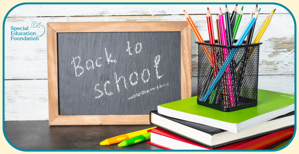 back to school written on a chalkboard with books and pencils next to it
