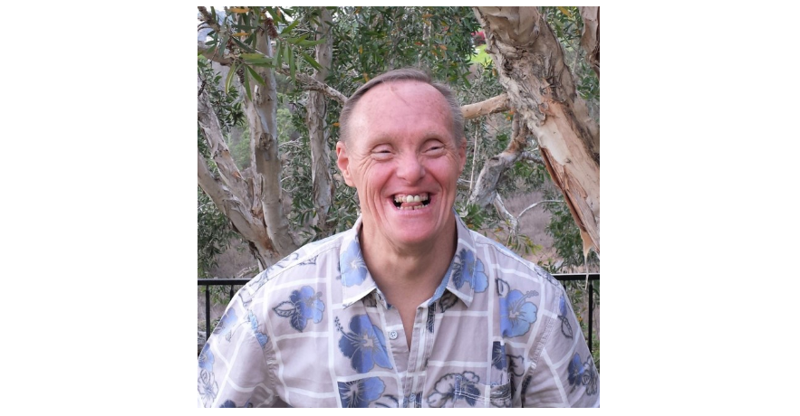 Photo of an old man smiling wearing a blue shirt on