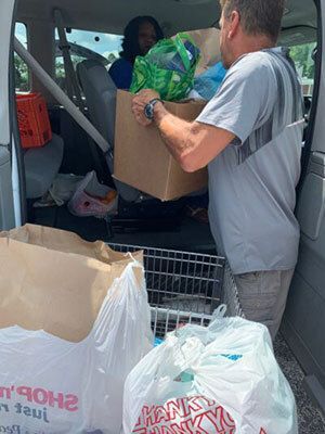 People loading up food boxes into a van.