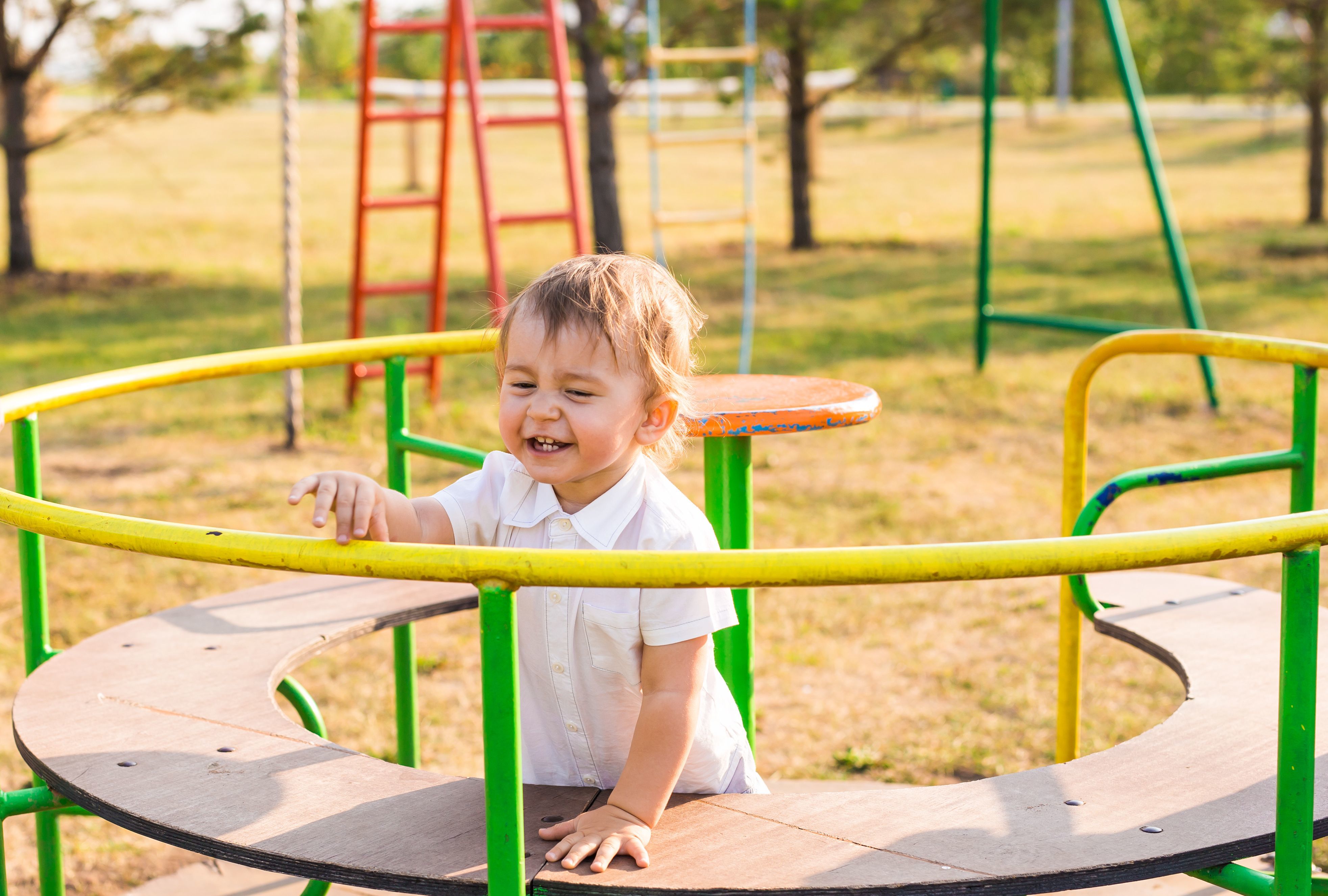 Young child playing in the park. He is happy and smiling. 