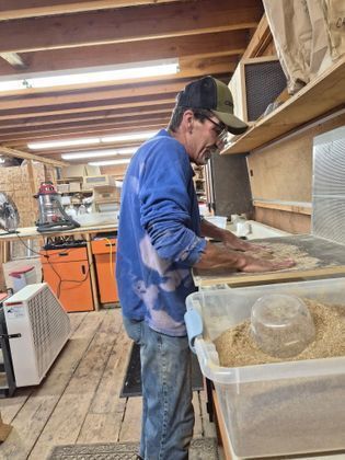 Billy cleaning seeds in EcoSource's Warehouse, Staff Member