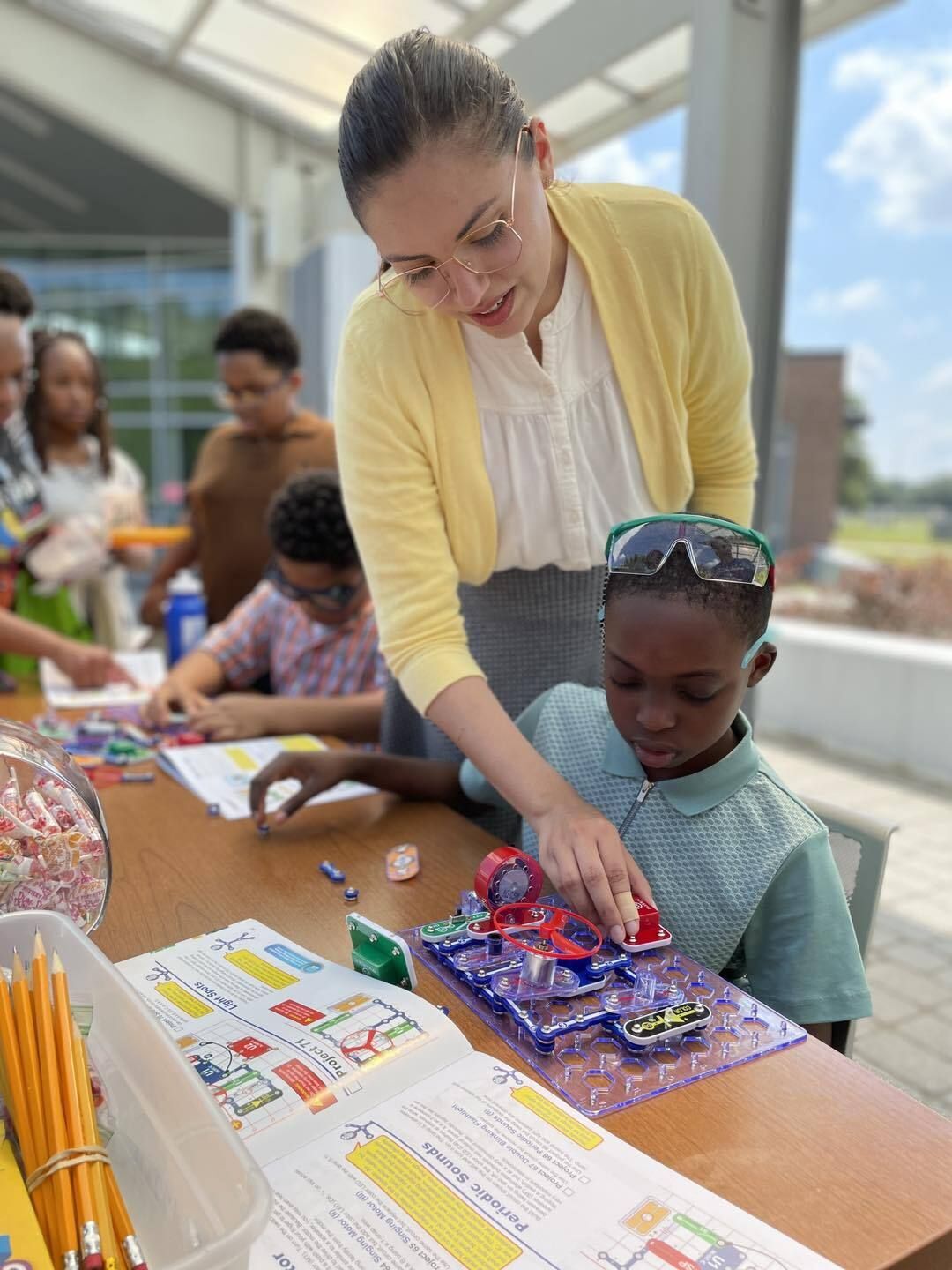 Camila Valenzuela, an AmeriCorps*VISTA who works at the LSU Gordon A. Cain Center for STEM Literacy, guides a student through the fascinating world of snap circuits, sparking curiosity and hands-on learning during the STEM Summer Kick-Off Event