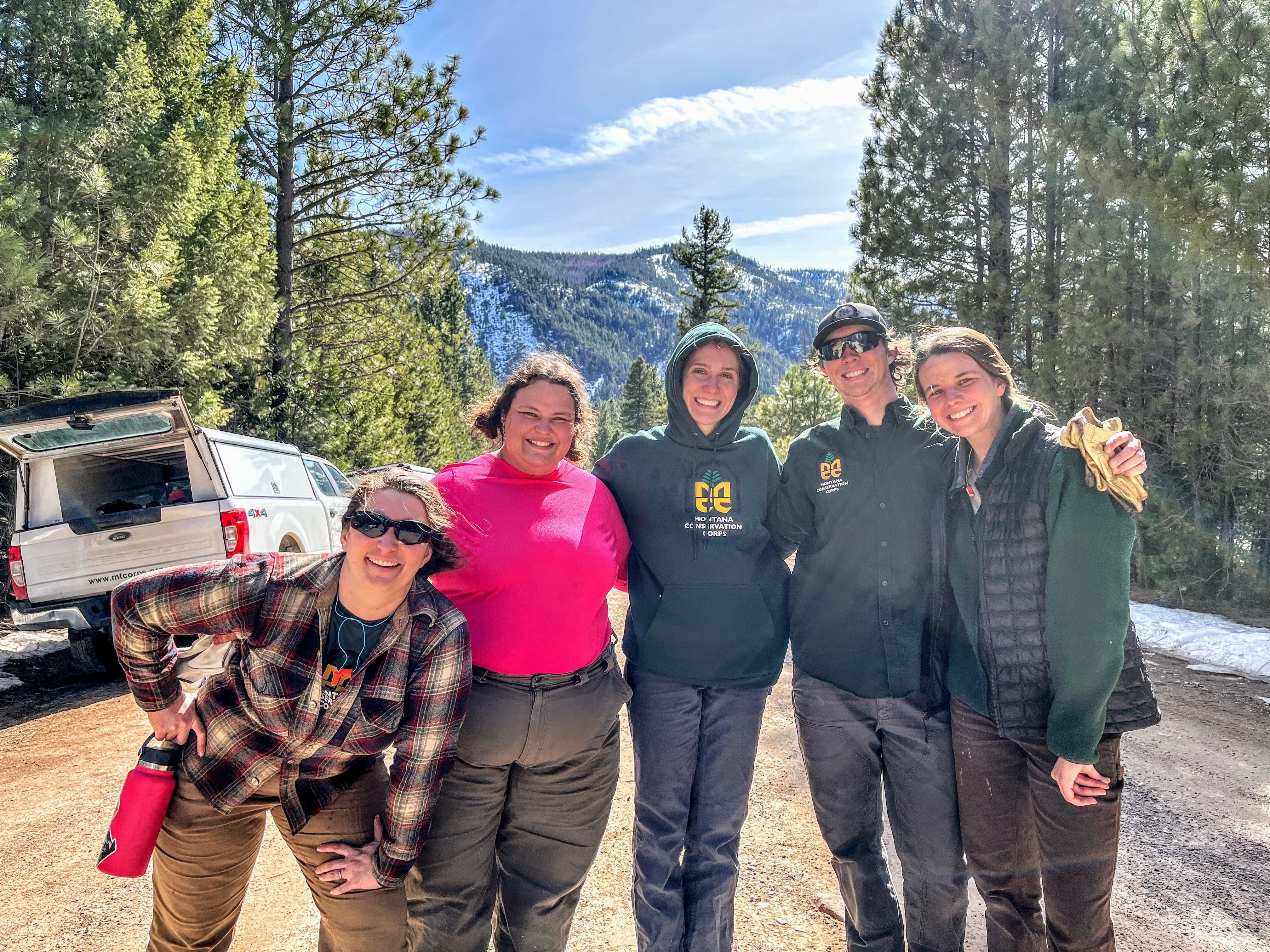 A group of MCC youth leaders poses on a dirt road.