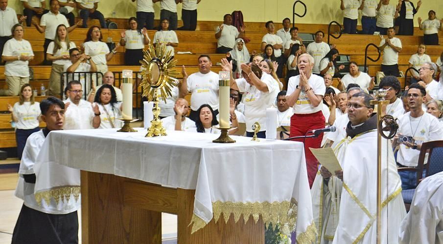 Fervent devotion is expressed during Eucharistic adoration at Encuentro 2025, led by Father Joaquín Fernández of the Heralds of the Gospel, May 25, 2025.
