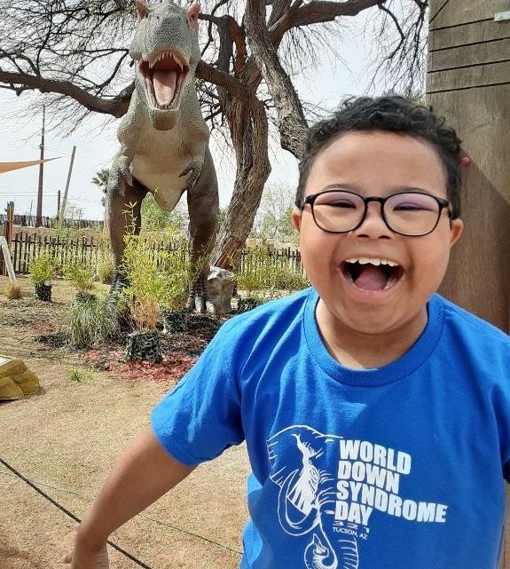 Smiling Boy with Dinosaur Statue