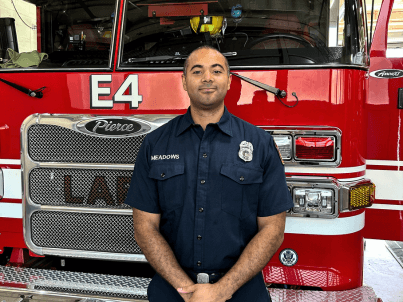 Firefighter Cory Meadows poses in front of LAFD Fire Station 4's engine.