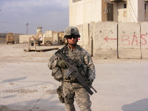 Ben Grimes in full uniform stands in front of a hospital in Iraq.