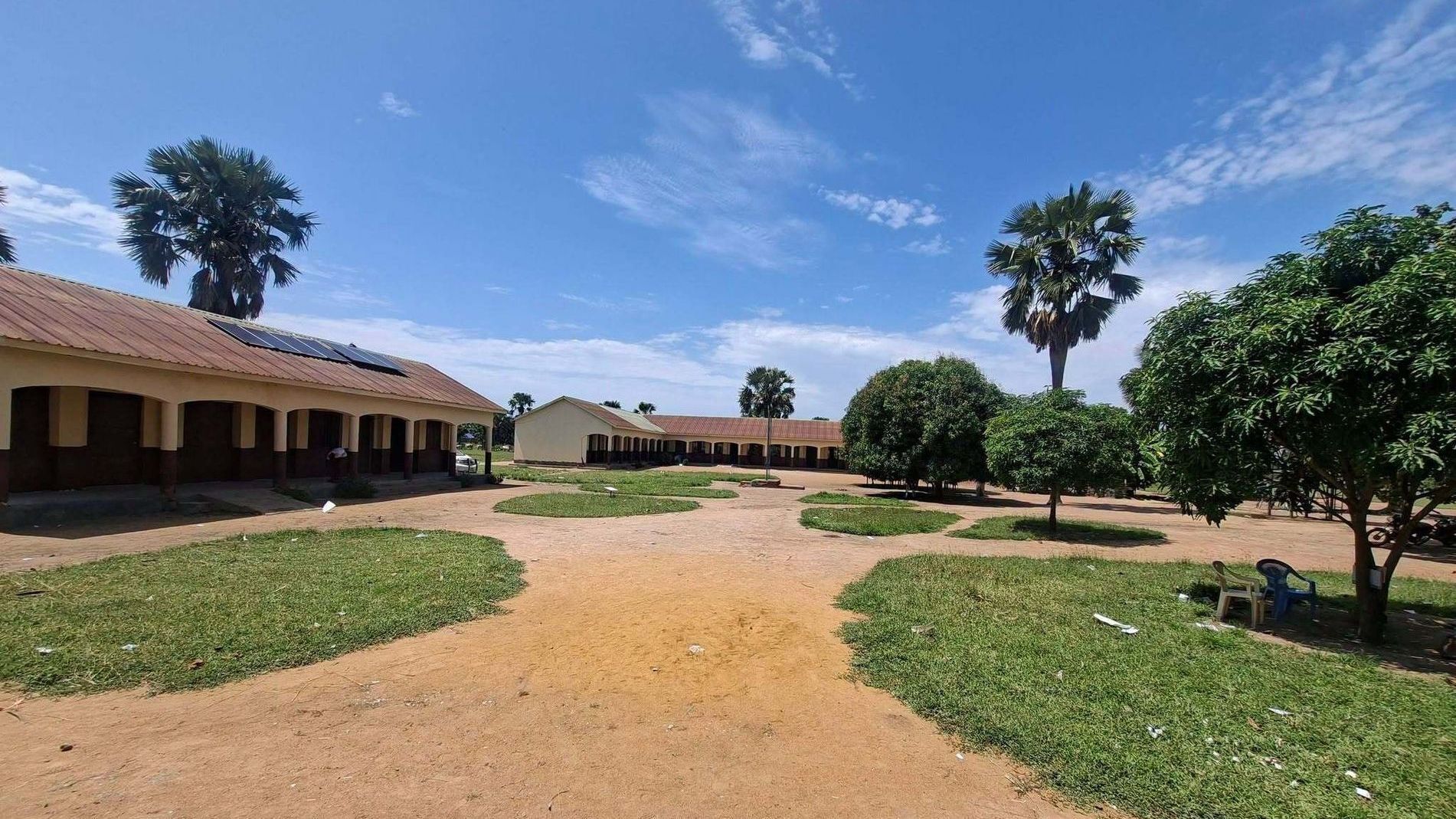 Two buildings and multiple fruit trees on Abukloi Secondary School's campus.