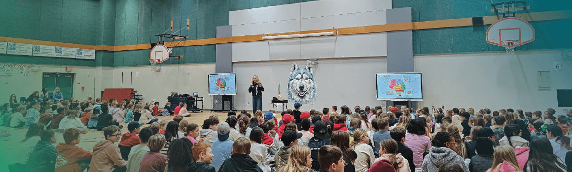 speaker presenting to young students in gym