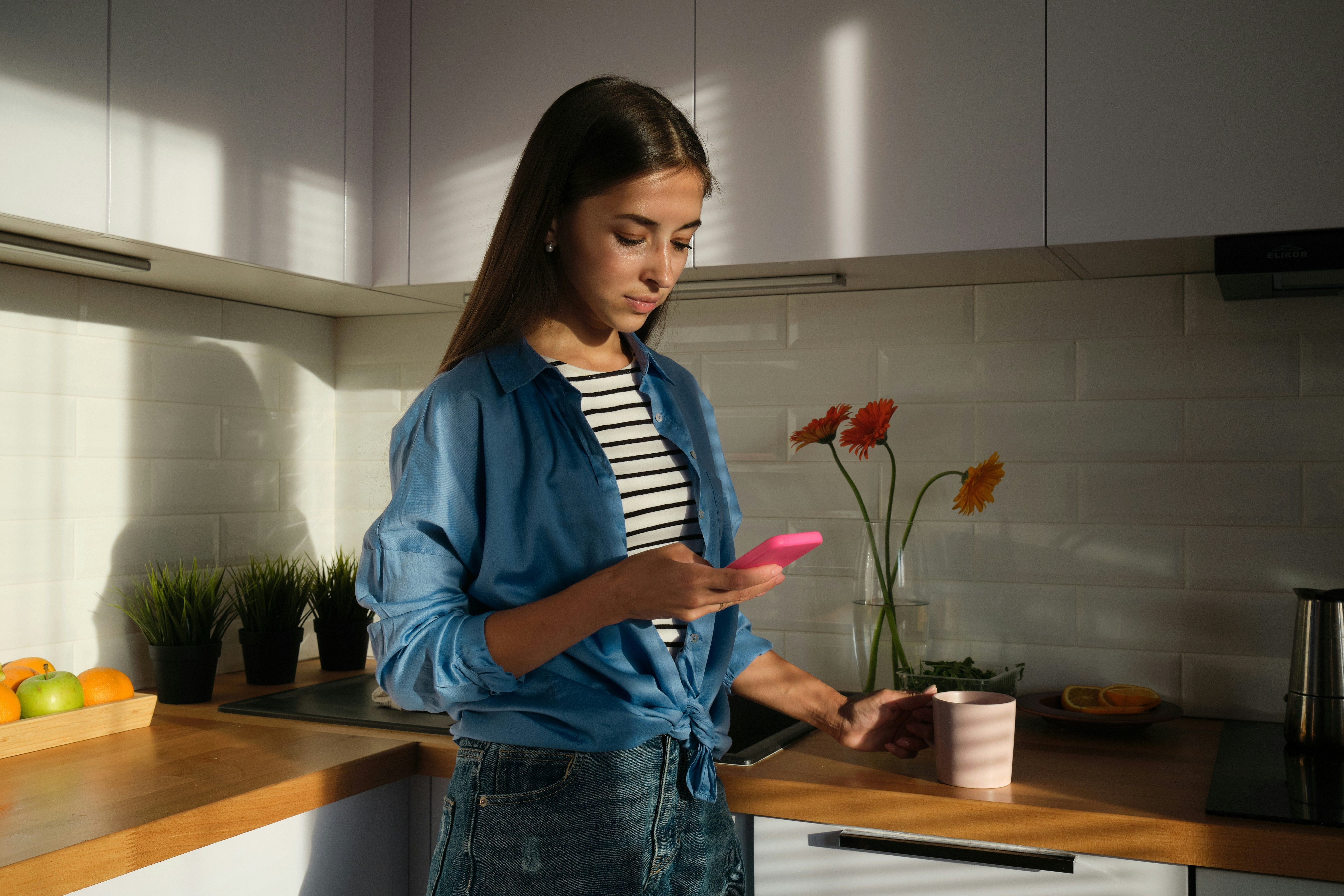 woman with brown hair looking at her phone