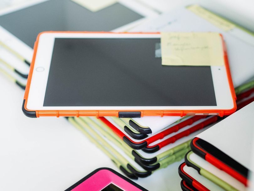 Stacks of iPads in colorful cases.