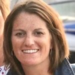 Head shot of a woman with chin length brown hair smiling into camera.