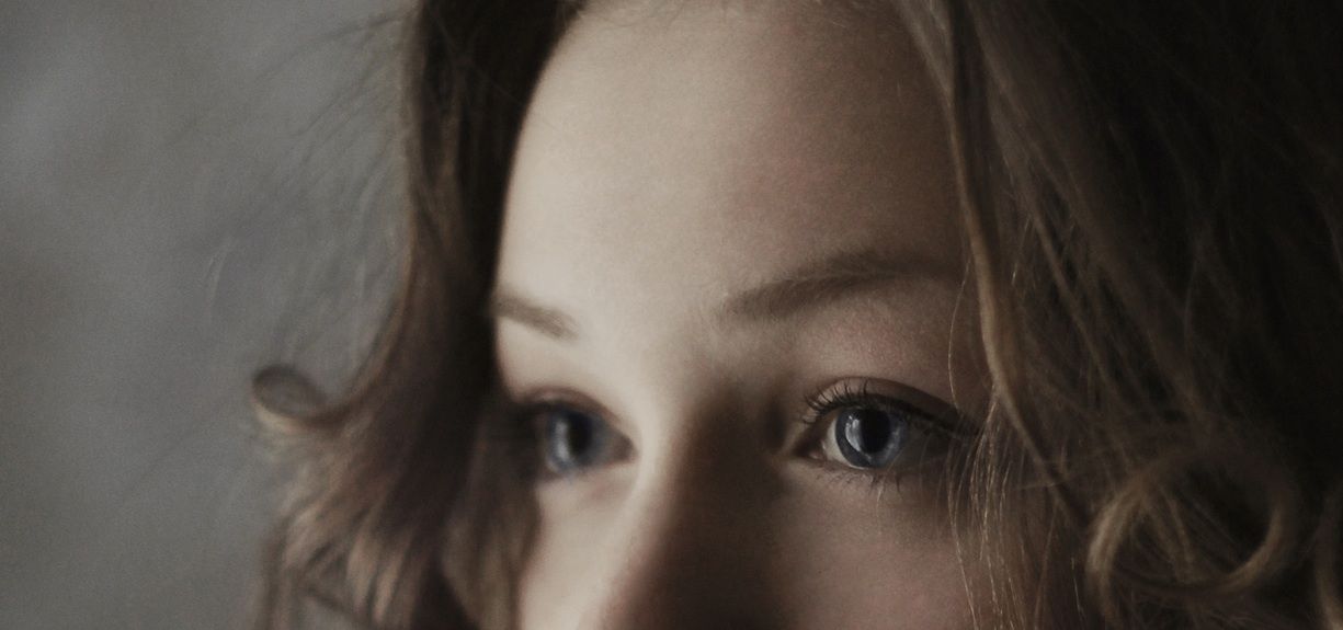 Close up of a young woman with big blue eyes.