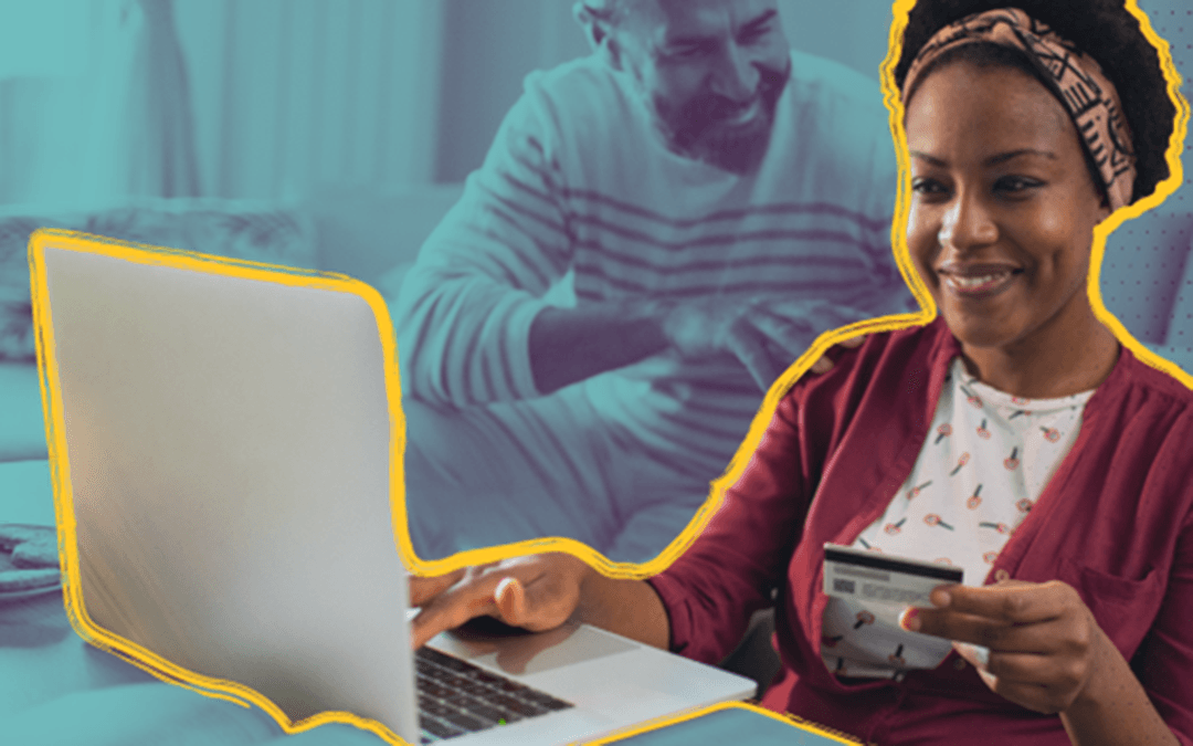Person with credit card smiling at laptop