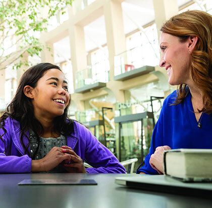 Girl smiling at woman outside.