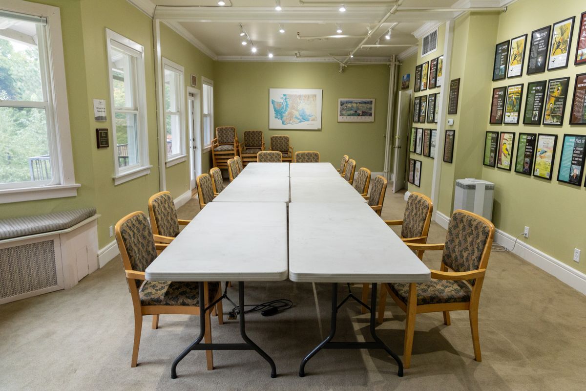 Several chairs set up around 6 long tables to mimic the conference style set-up for the Bird Fest Room.