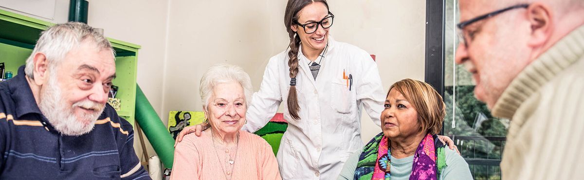 Nurse with retired patients playing chess