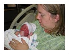 Mom in hospital gown with an infant in her arms