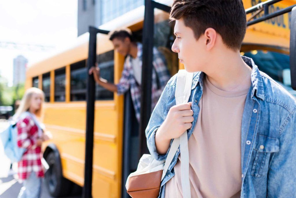 Photo of students getting off a school bus. 