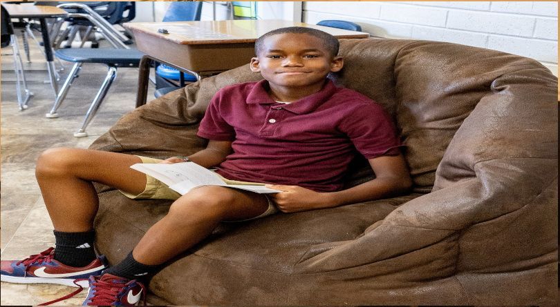 Student smiling and reading a book