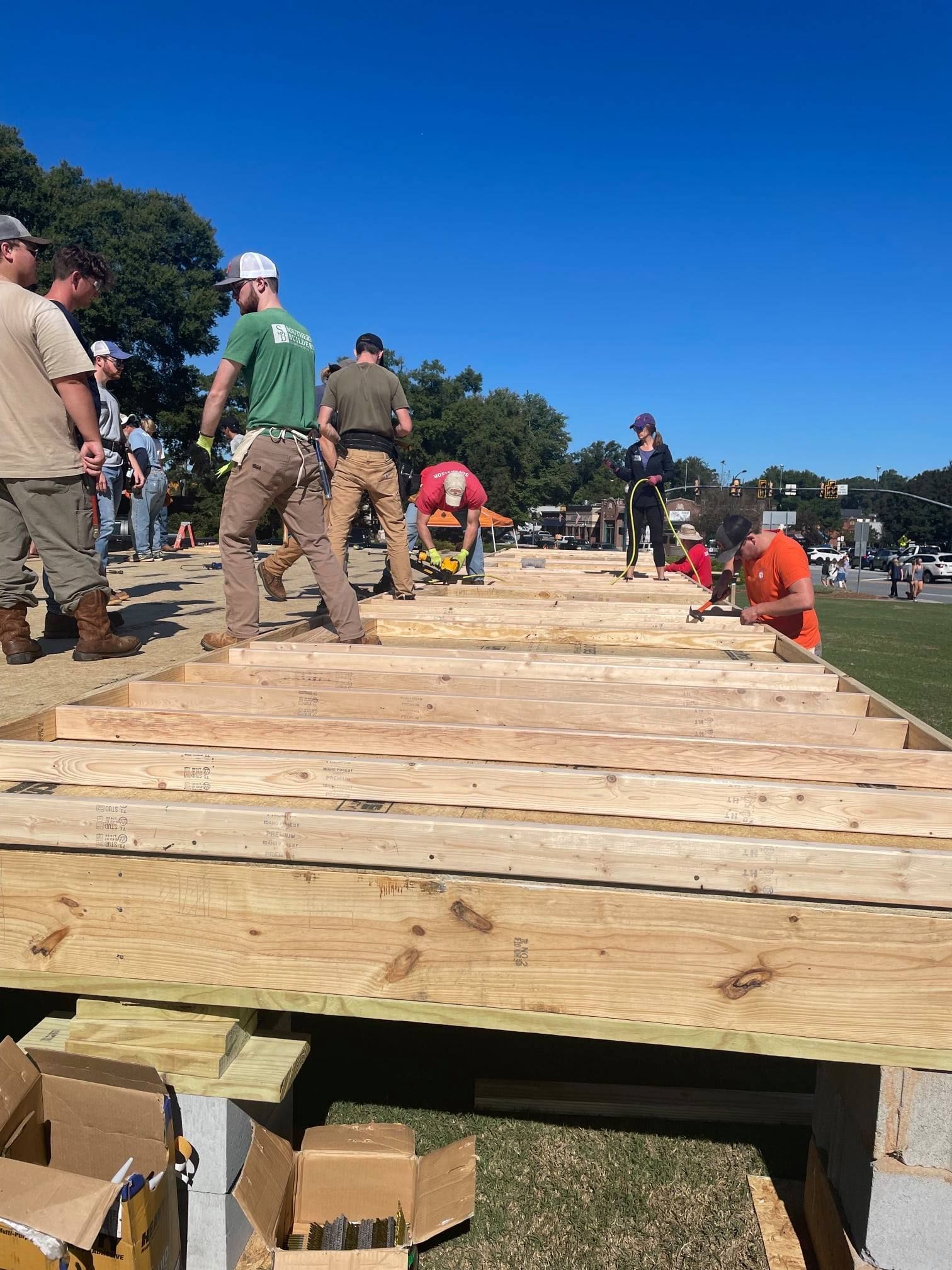 Students and community volunteers build the floor joists on the 2021 Homecoming Build.