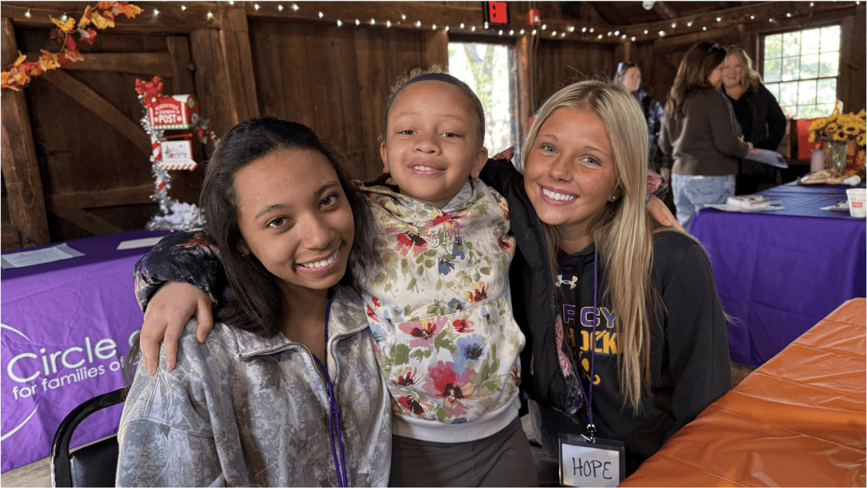 Two volunteers pose with a young event attendee in Wethersfield