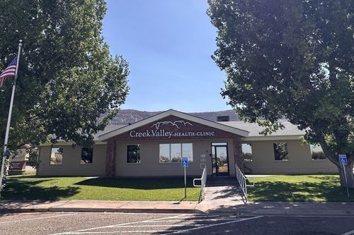 Image of Creek Valley Health Clinic, brick building with big trees