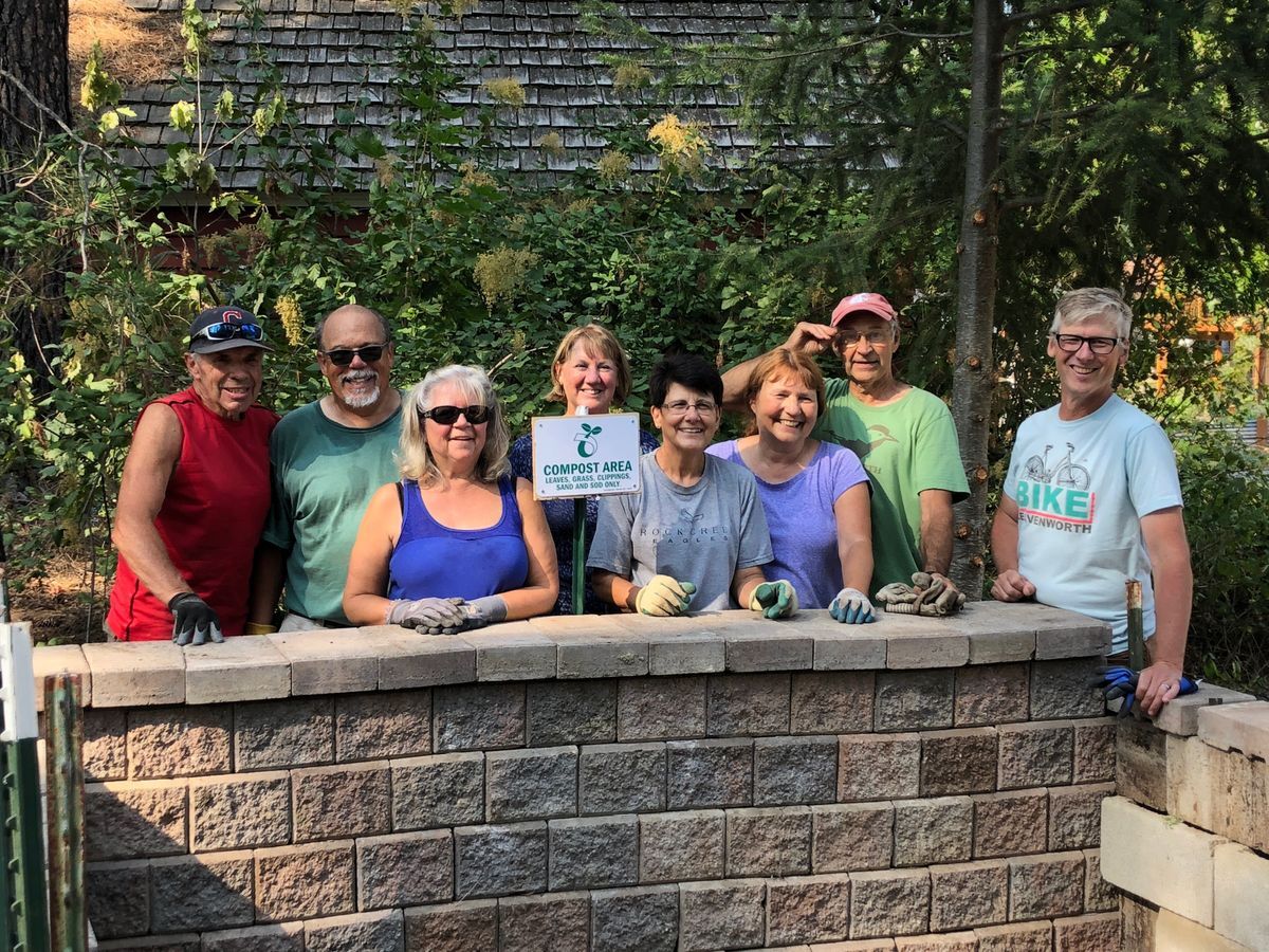 A group of volunteers posed at the compost area they developed for the garden years ago.