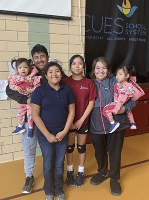 Mother holding child, father holding child and two school age daughters.