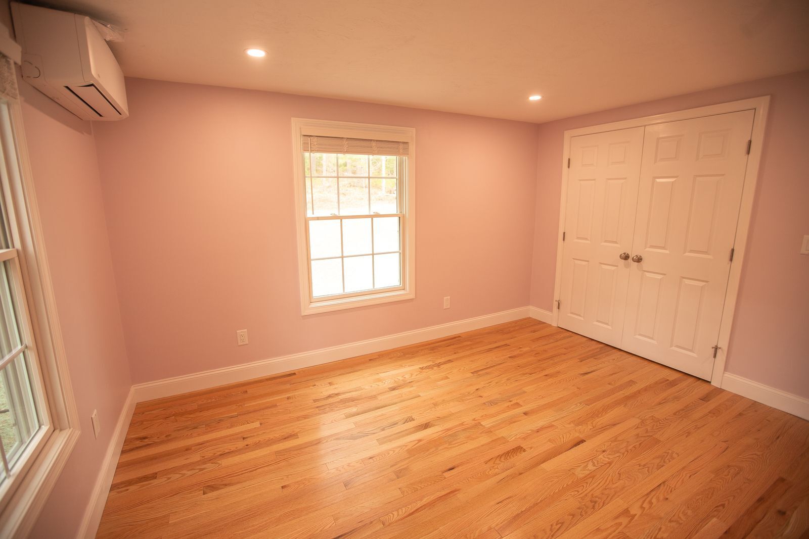 A photo of an empty bedroom with beige walls