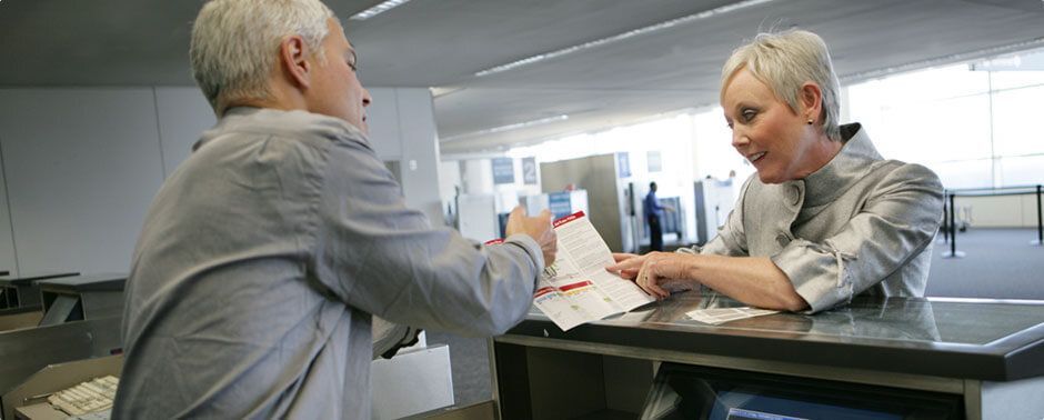 Man and woman looking at a brochure over a sales counter.