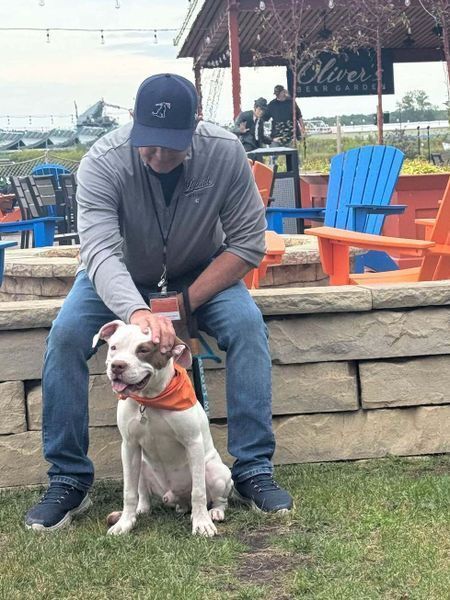 Volunteer sitting with shelter dog at a fundraising event